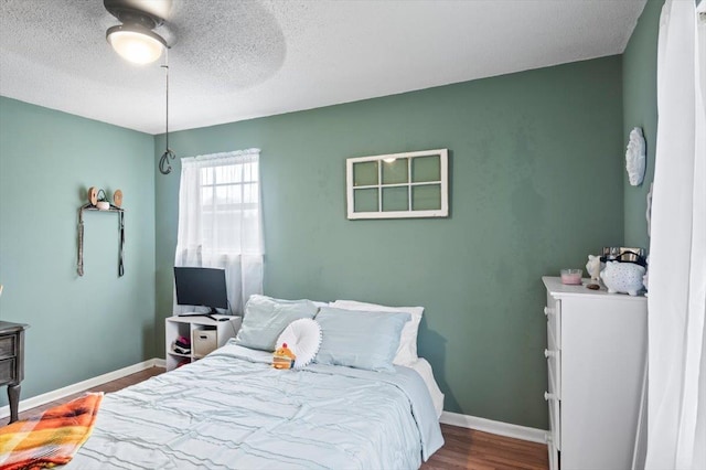 bedroom featuring wood-type flooring, a textured ceiling, and ceiling fan