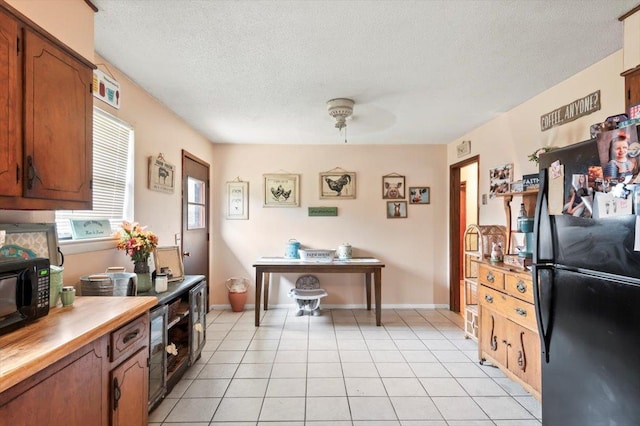 kitchen featuring black appliances, ceiling fan, light tile patterned floors, and a textured ceiling