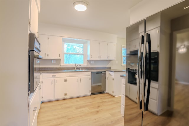 kitchen featuring stainless steel appliances, sink, light hardwood / wood-style flooring, and white cabinets