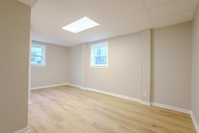 empty room featuring a paneled ceiling and light hardwood / wood-style floors