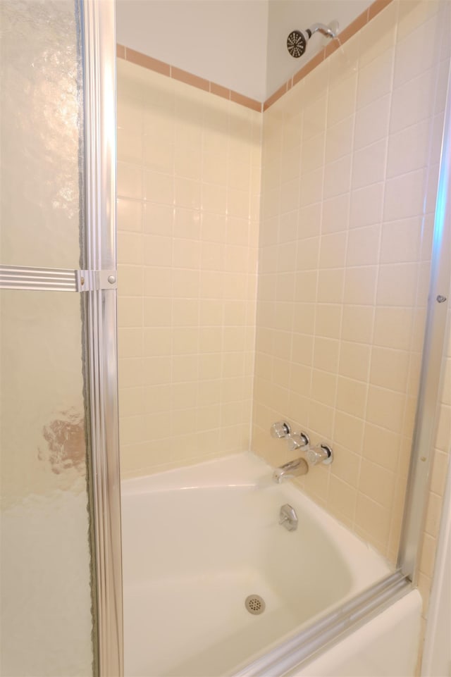 bathroom featuring bath / shower combo with glass door