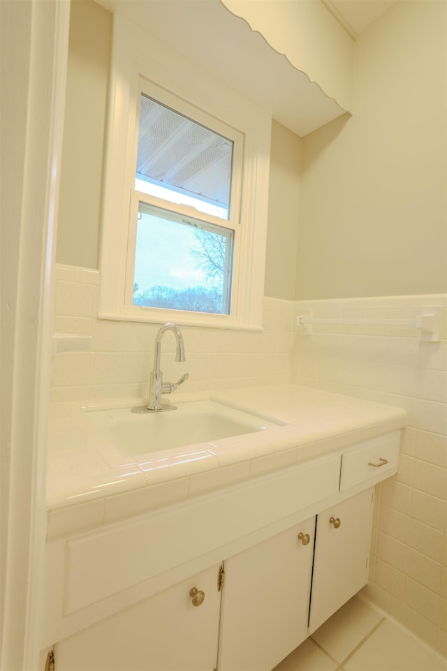 bathroom featuring vanity, tile patterned flooring, and tile walls