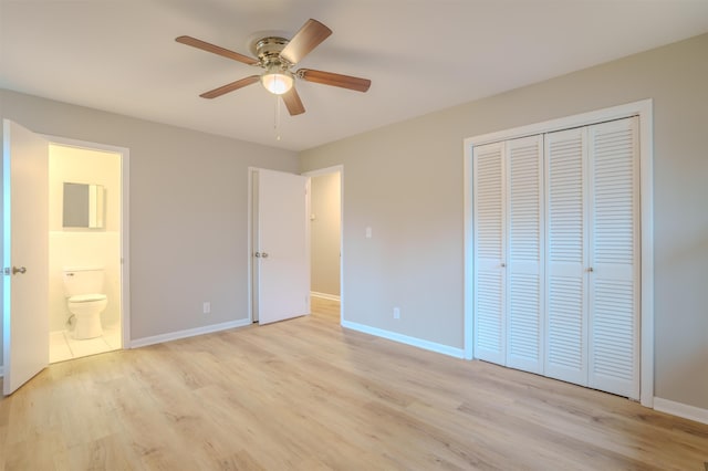 unfurnished bedroom with a closet, ensuite bathroom, ceiling fan, and light hardwood / wood-style flooring