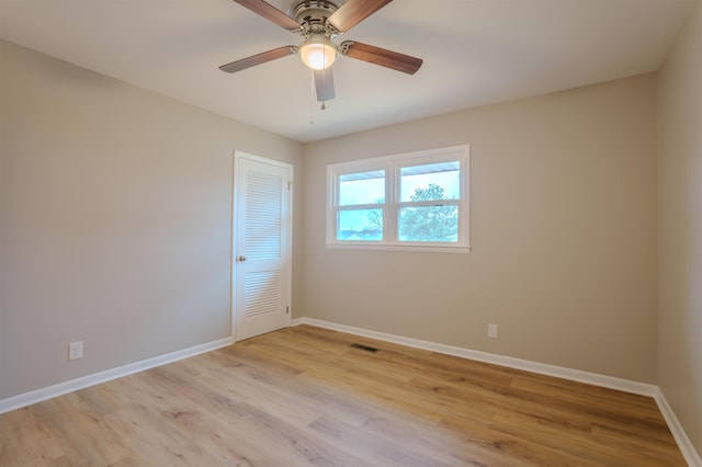 spare room with ceiling fan and light wood-type flooring