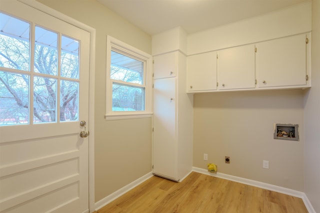 clothes washing area featuring washer hookup, cabinets, light hardwood / wood-style flooring, and hookup for an electric dryer