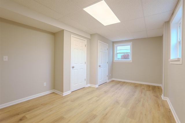 interior space with a paneled ceiling and light wood-type flooring