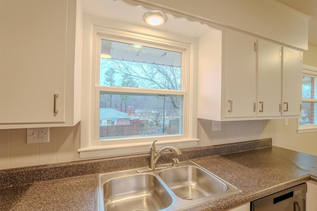 kitchen with white cabinetry, sink, and dishwashing machine