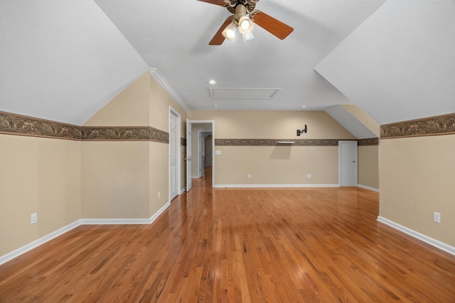 additional living space with hardwood / wood-style floors, a textured ceiling, and ceiling fan