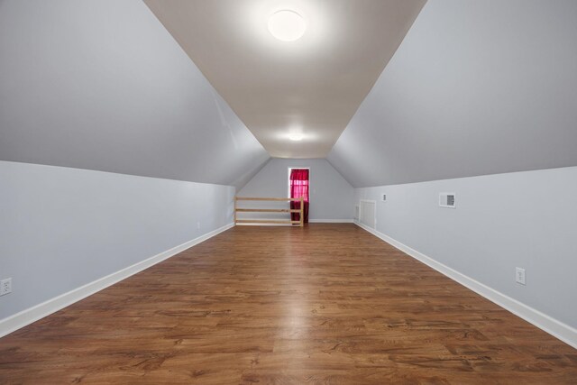 additional living space featuring dark hardwood / wood-style floors and lofted ceiling