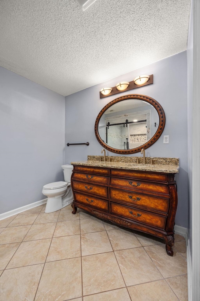 bathroom with tile patterned flooring, vanity, toilet, and a textured ceiling