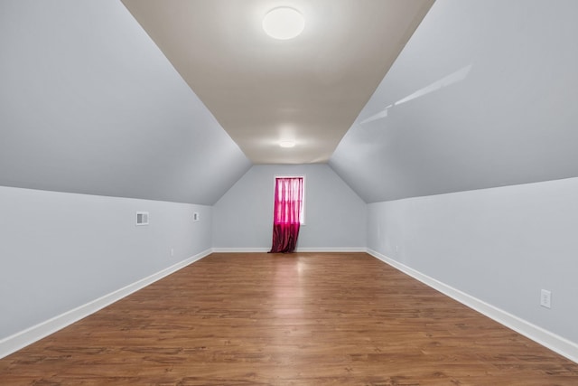 additional living space featuring hardwood / wood-style floors and lofted ceiling