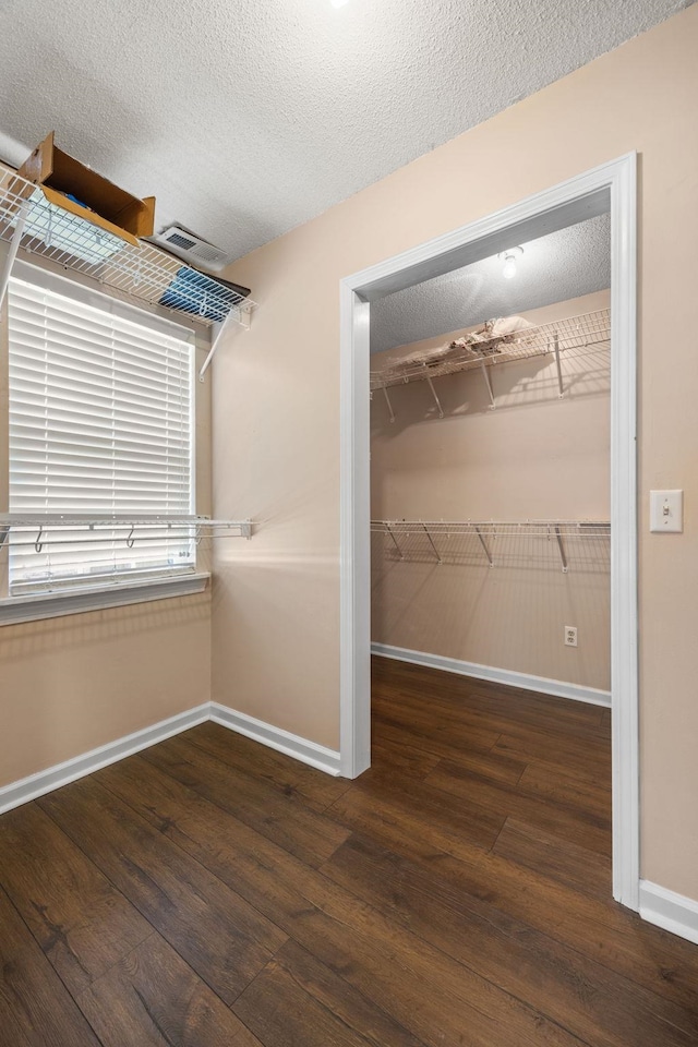 spacious closet with dark hardwood / wood-style flooring