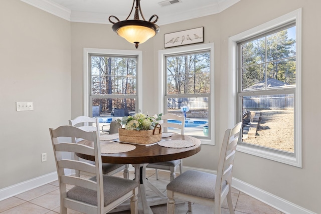 tiled dining space with crown molding and a healthy amount of sunlight