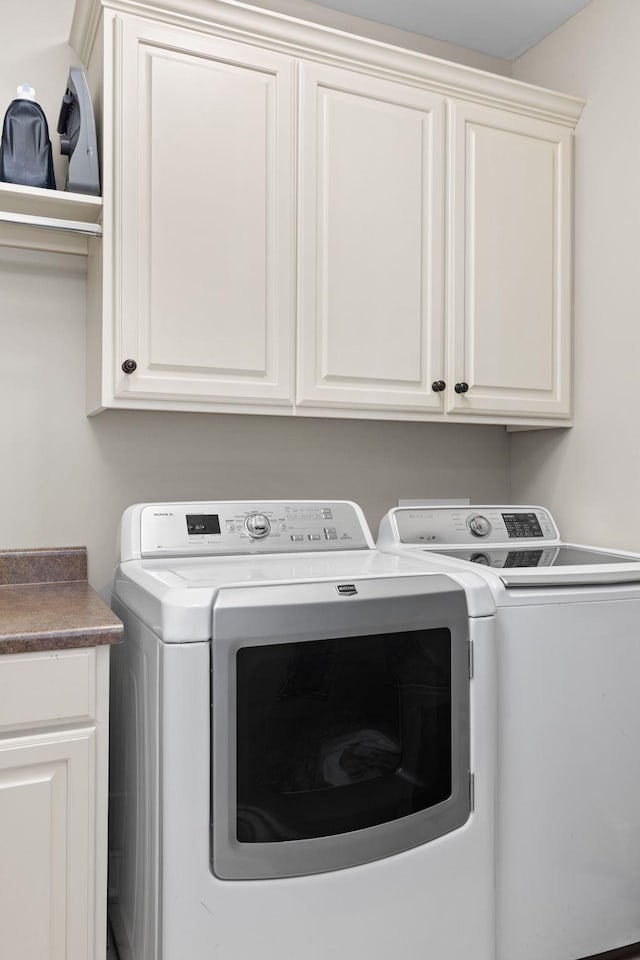 washroom with cabinets and washer and dryer