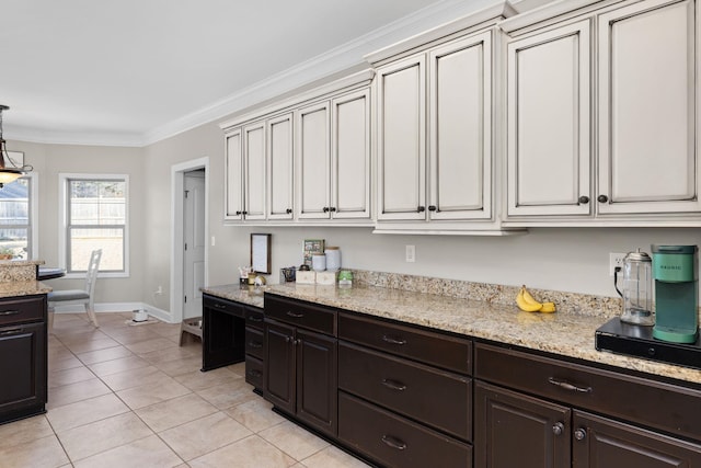 kitchen featuring light tile patterned flooring, ornamental molding, decorative light fixtures, and light stone countertops