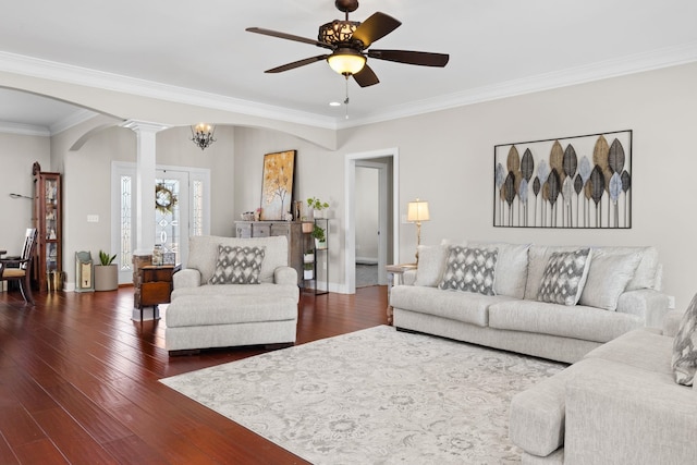 living room with ornate columns, crown molding, dark wood-type flooring, and ceiling fan