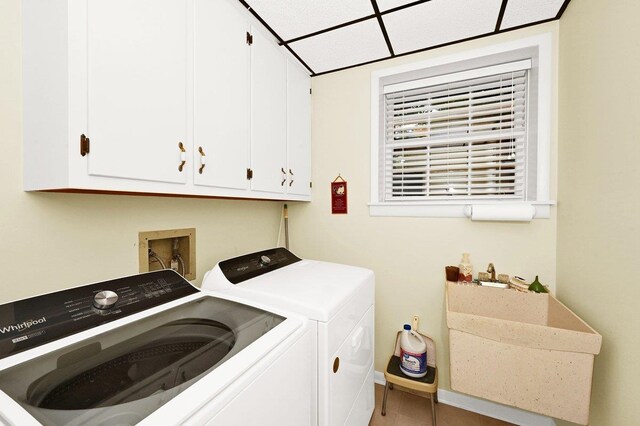 laundry room featuring cabinets, separate washer and dryer, and sink