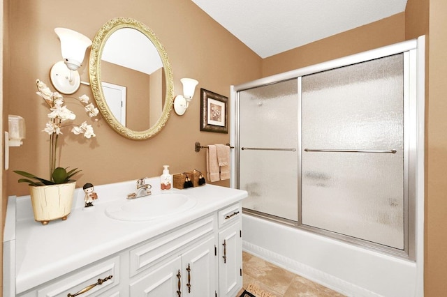 bathroom featuring combined bath / shower with glass door and vanity