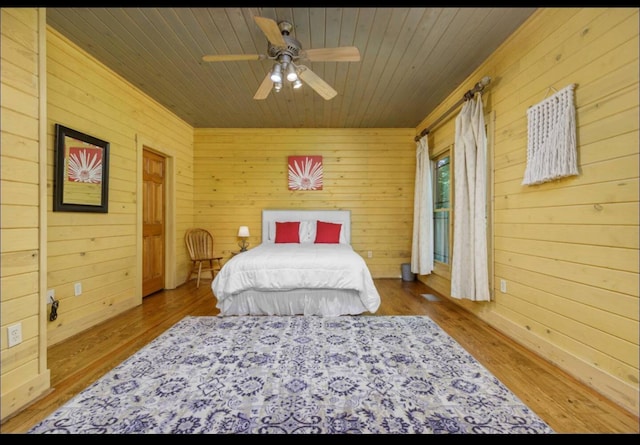 bedroom with wooden ceiling, wood walls, wood finished floors, and ceiling fan