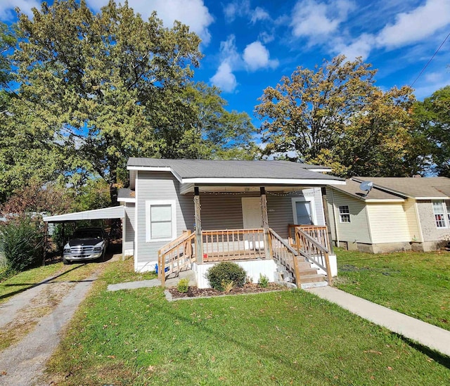 view of front facade with a carport, a porch, and a front lawn