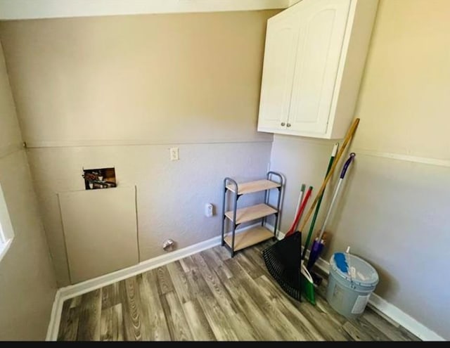 clothes washing area with hookup for a washing machine, cabinets, and wood-type flooring