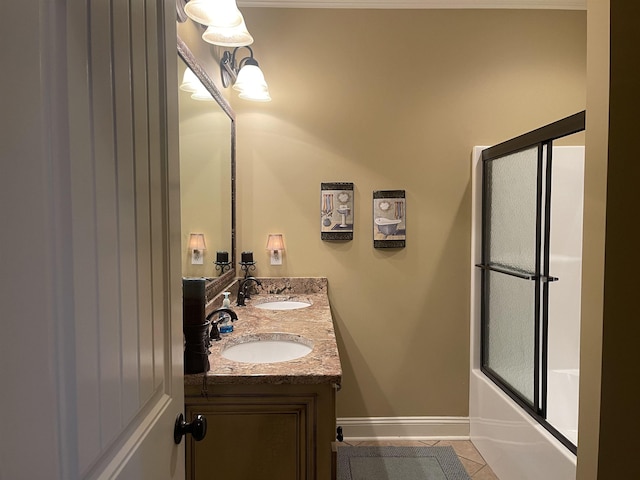 bathroom featuring tile patterned flooring, vanity, and shower / bath combination with glass door