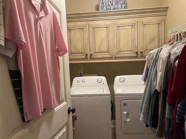 laundry area with washer and clothes dryer and cabinets