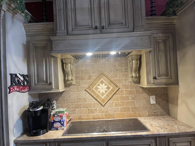 kitchen featuring custom exhaust hood, black electric stovetop, backsplash, and light stone counters