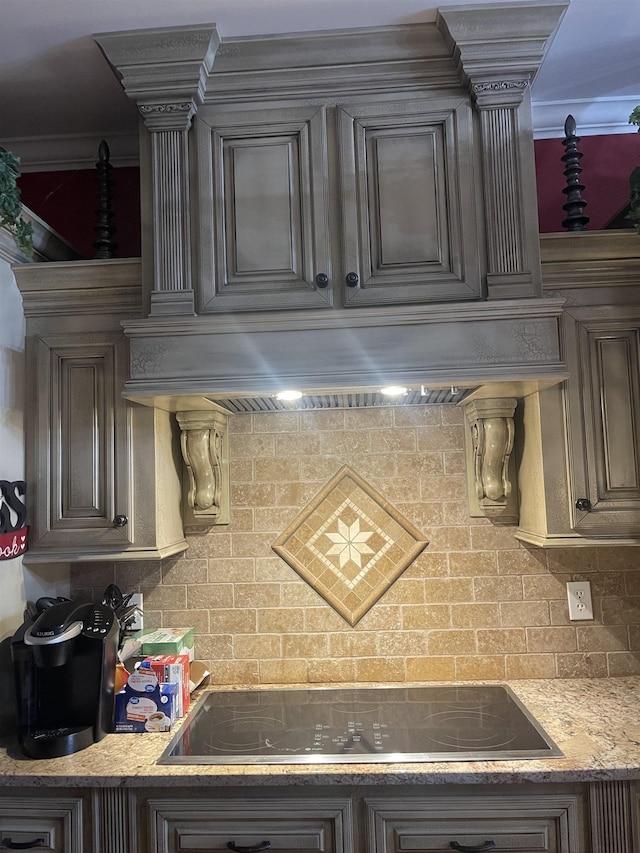 kitchen featuring premium range hood, black electric stovetop, backsplash, and dark brown cabinetry