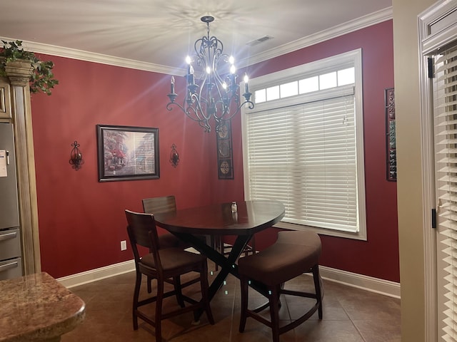 dining room with dark tile patterned flooring, crown molding, and a chandelier