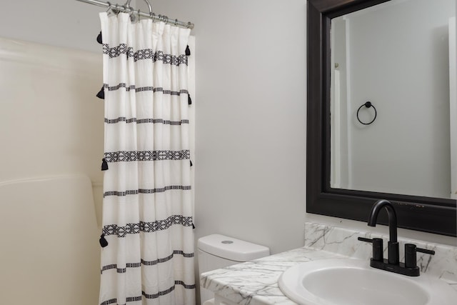 full bathroom featuring curtained shower, a sink, and toilet