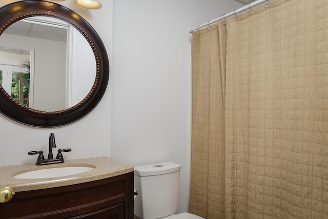 full bathroom featuring a shower with shower curtain, vanity, and toilet