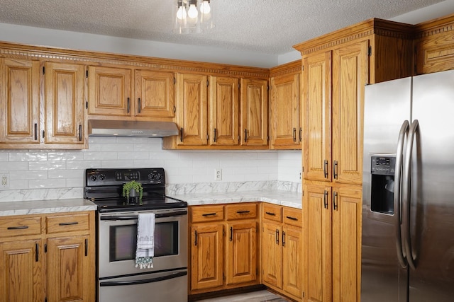 kitchen featuring stainless steel appliances, backsplash, light countertops, and under cabinet range hood