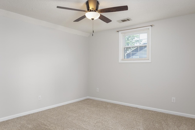 unfurnished room with carpet floors, baseboards, visible vents, and a textured ceiling