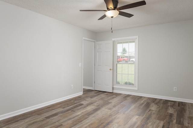 spare room featuring ceiling fan, a textured ceiling, baseboards, and wood finished floors