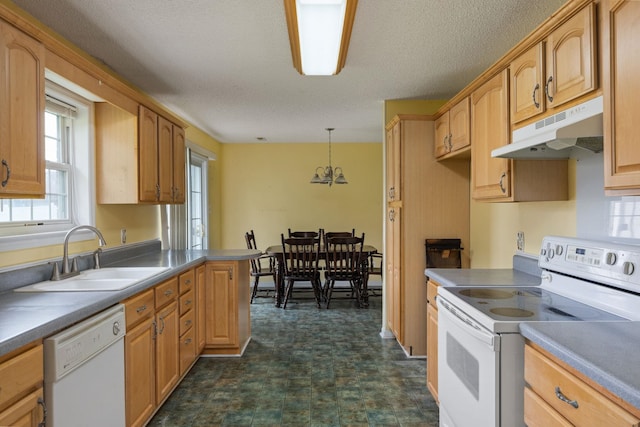  - kitchen with white appliances, under cabinet range hood, a sink, pendant lighting, and a chandelier