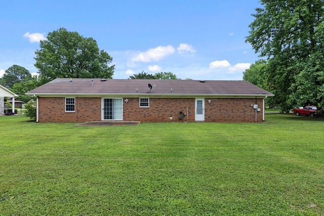  - back of house featuring a yard, brick siding, and a patio area