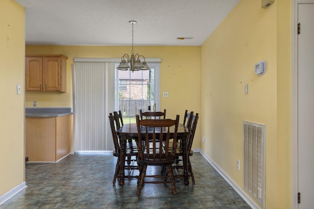  - dining area with a chandelier, baseboards, and a textured ceiling