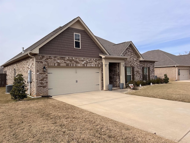 view of front of property with a garage, a front yard, and central AC