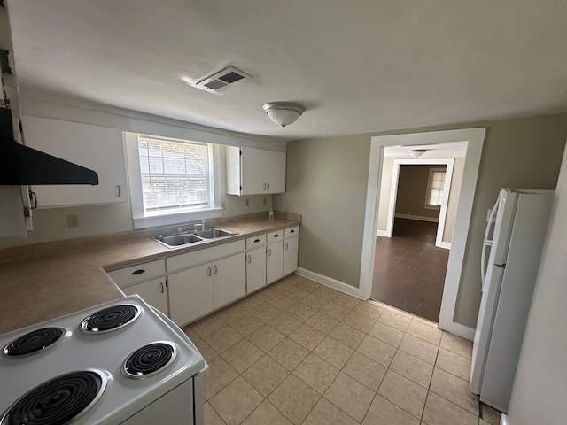 kitchen featuring range, white refrigerator, white cabinetry, and sink