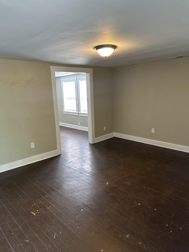 spare room with dark wood-type flooring