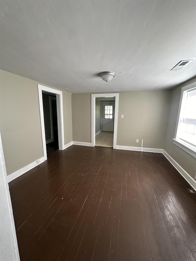 empty room featuring dark hardwood / wood-style flooring and a textured ceiling