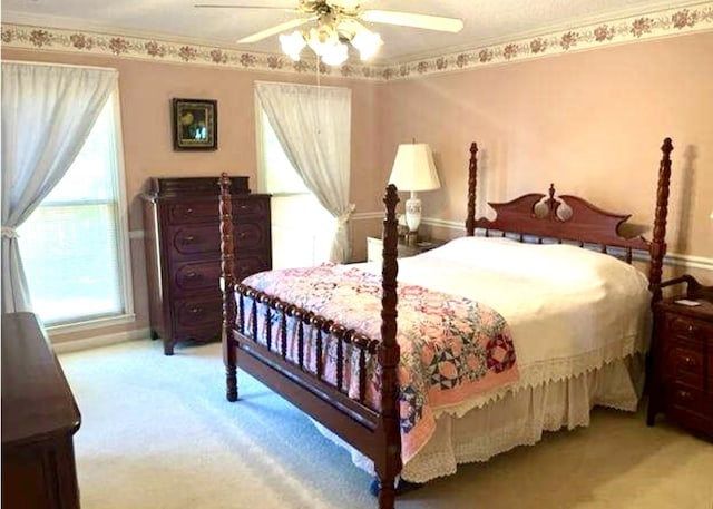 bedroom with ceiling fan and light carpet