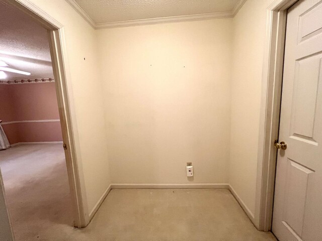 carpeted empty room with ceiling fan, crown molding, and a textured ceiling