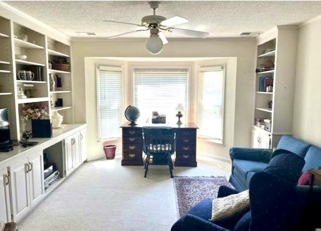 carpeted home office with built in features, a healthy amount of sunlight, and a textured ceiling