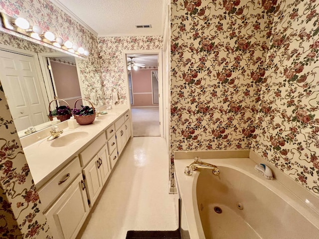 bathroom featuring a bathtub, vanity, a textured ceiling, and ornamental molding