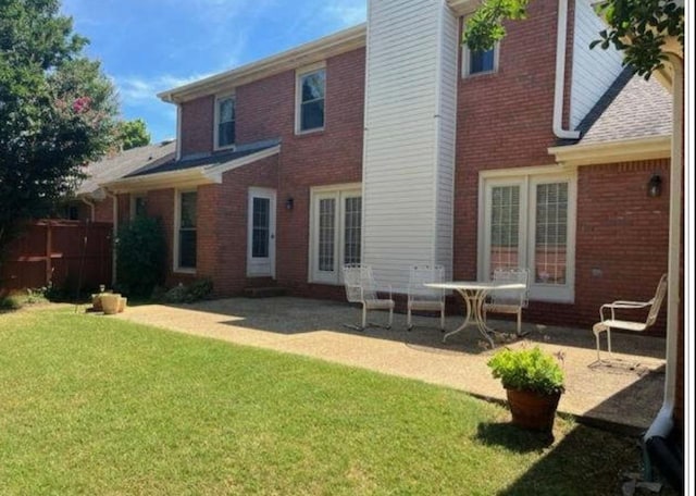 back of property with a patio and a lawn