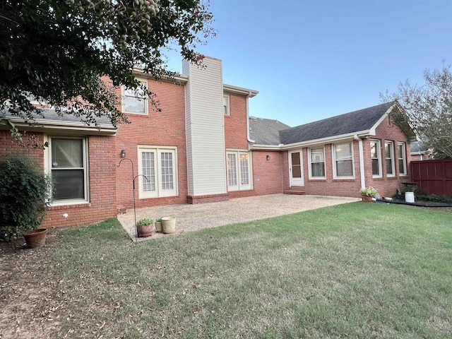 back of property featuring a lawn and a patio