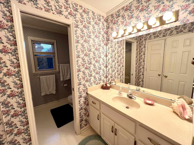 bathroom with a textured ceiling, vanity, toilet, and ornamental molding