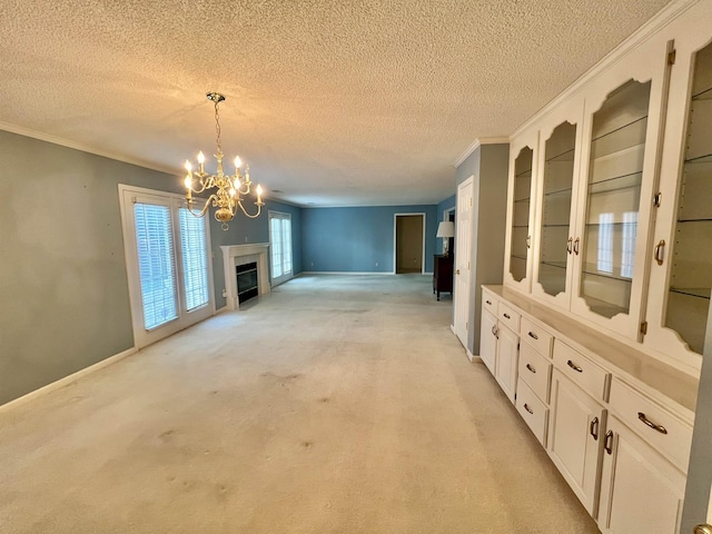 unfurnished living room with ornamental molding, a textured ceiling, light carpet, and an inviting chandelier